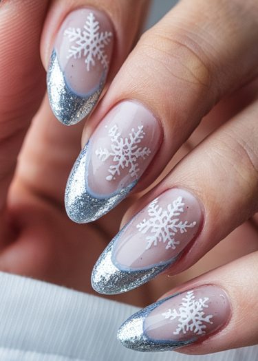 Elegant winter snowflake nail art with silver tips on almond-shaped, manicured nails.