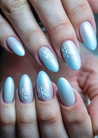 Elegant winter nail art featuring icy blue polish and intricate snowflake designs.