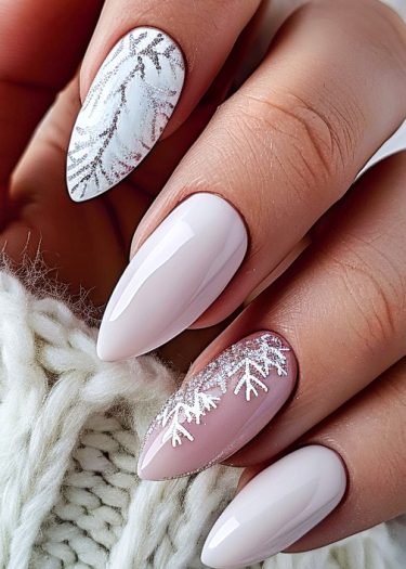 Elegant winter-themed almond nails with snowflake designs in creamy nude and shimmering silver.