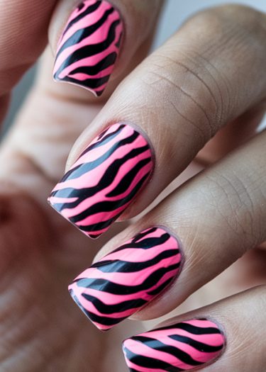 Bold zebra stripe nail art in black and pink with a glossy finish.